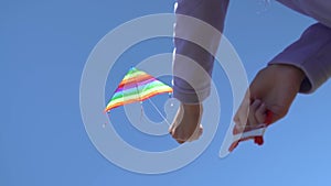 Happy young woman running with a kite on a glade at sunset in summer