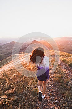 Happy young woman running in sunset light. Freedom concept