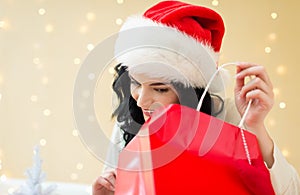 Happy young woman with santa hat holding a shopping bag