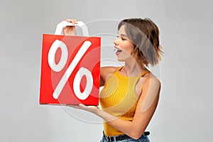 Happy young woman with shopping bag on sale