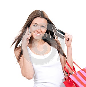 Happy young woman with shopping bags and credit card