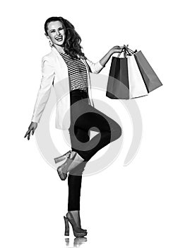 Happy young woman with shopping bags posing on white background
