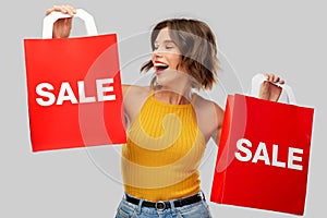 Happy young woman with shopping bags on sale