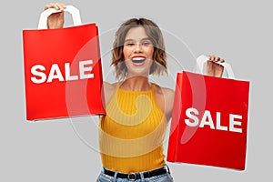 Happy young woman with shopping bags on sale