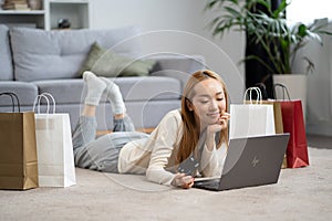 Happy Young Woman Shopping Online at Home with Credit Card