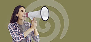 Happy young woman shouting into megaphone making announcement