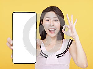 Happy Young woman  showing blank screen Smart phone and ok gesture