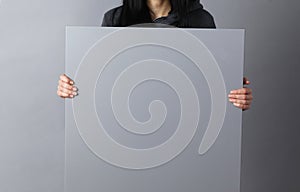 Happy young woman showing and displaying placard ready for your text or product photo