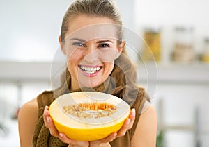 Happy young woman showing melon slice