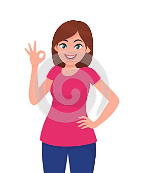 Happy young woman showing okay/OK sign or gesture with fingers. Woman standing and showing super or O sign. Cool, agree, approve.