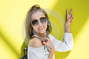 Happy young woman showing peace sign - two fingers