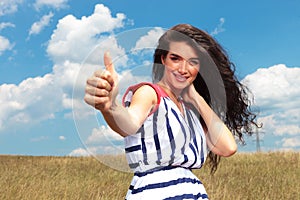 Happy young woman showing the thumbs up gesture