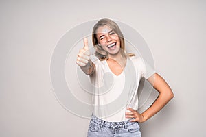 Happy young woman showing thumbs up isolated on white background