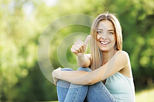 Happy young woman showing thumbs up sign