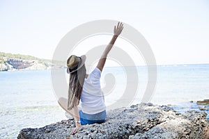 Happy young woman sitting, enjoy life on the beach at Sea.