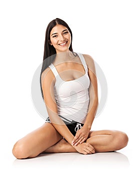 Happy young woman sitting on the floor