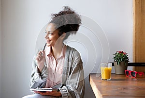 Happy young woman sitting at home with pen and paper