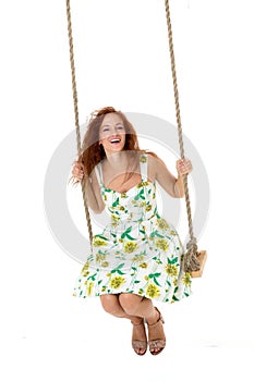 Happy young woman sitting on rope swing