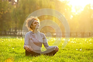 Happy young woman sitting in yoga position