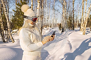 Happy young woman skier enjoying winter vacation in the mountains and taking a selfie