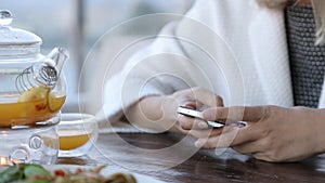 Happy young woman with smartphone in cafe