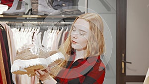 Happy young woman smiling to the camera while shopping for footwear