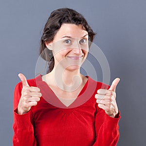 Happy young woman smiling with two thumbs up for excitement photo