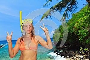 Happy young woman in snorkeling mask on tropical island beach