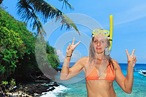 Happy young woman in snorkeling mask on tropical island beach