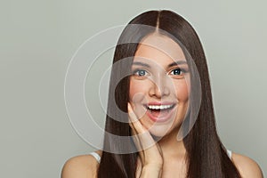 Happy young woman spa model with clear skin and long healthy straight hair. Skincare and facial treatment concept