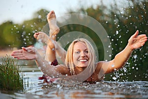 Šťastný mladá žena stříkající voda 