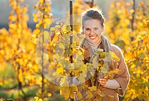 Happy young woman standing in autumn vineyard