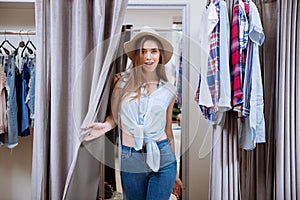 Happy young woman standing in fitting room