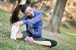 Happy young woman stretching before running outdoors