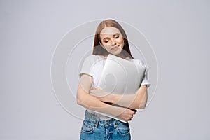 Happy young woman student holding laptop computer with closed eyes on isolated gray background.