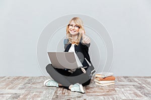 Happy young woman student using laptop computer.