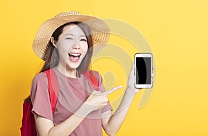 Happy young woman in summer hat and showing smart phone