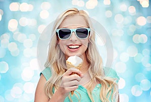 Happy young woman in sunglasses eating ice cream