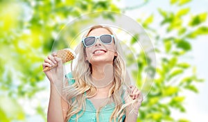 Happy young woman in sunglasses eating ice cream