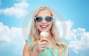 Happy young woman in sunglasses eating ice cream