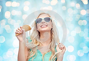 Happy young woman in sunglasses eating ice cream