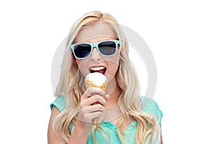 Happy young woman in sunglasses eating ice cream