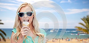 Happy young woman in sunglasses eating ice cream