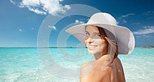 Happy young woman in sunhat over summer beach