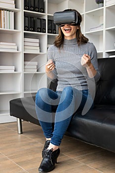 Happy young woman surprised in VR headset, feeling air. Smiling caucasian woman wearing vr glasses,