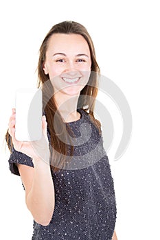 Happy young woman in sweater showing blank smartphone screen