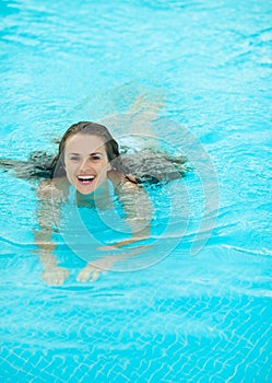 Happy young woman swimming in pool