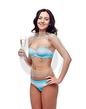 Happy young woman in swimsuit drinking champagne