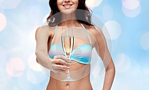 Happy young woman in swimsuit drinking champagne