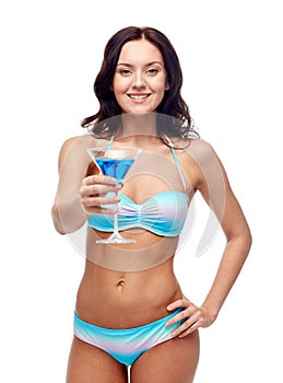 Happy young woman in swimsuit drinking cocktail